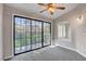 This living room features a sliding glass door and neutral carpeting and paint at 4905 Ocean Shores Way, Las Vegas, NV 89130
