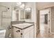 An ensuite bathroom with granite countertop, decorative mirror, and tile shower adjacent to the bedroom at 4955 Lindell Rd # 130, Las Vegas, NV 89118