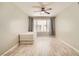 A well lit bedroom featuring neutral walls, wood-look flooring, and a window with stylish patterned curtains at 4955 Lindell Rd # 130, Las Vegas, NV 89118