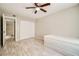 A bedroom featuring neutral walls, wood-look flooring, a ceiling fan, closet and an ensuite bathroom at 4955 Lindell Rd # 130, Las Vegas, NV 89118
