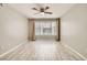 Bedroom featuring wood-look flooring, a ceiling fan, and a window with curtains at 4955 Lindell Rd # 130, Las Vegas, NV 89118