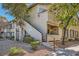 Stucco condo with front porch and access stairs is surrounded by trees and landscaping at 4955 Lindell Rd # 130, Las Vegas, NV 89118