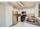 Clean kitchen features stainless steel refrigerator, white cabinets, gas range and granite counters at 4955 Lindell Rd # 130, Las Vegas, NV 89118