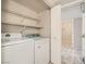 A laundry room equipped with a washer, dryer and wire shelving for storage and organizing laundry supplies at 4955 Lindell Rd # 130, Las Vegas, NV 89118