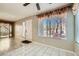 Open living room with tile and wood-style floors, bright windows, and access to the front door at 4955 Lindell Rd # 130, Las Vegas, NV 89118