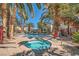 Hot tub and community pool area surrounded by palm trees and foliage under a clear sky at 4955 Lindell Rd # 130, Las Vegas, NV 89118