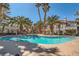 Resort-style community pool surrounded by palm trees, lounge chairs, and well-kept landscaping at 4955 Lindell Rd # 130, Las Vegas, NV 89118