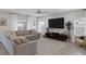 Cozy living room with a comfortable sectional sofa, ceiling fan, TV, and large windows providing natural light at 5234 Savannah Rose St, Las Vegas, NV 89149
