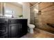 Bathroom featuring granite countertops, dark cabinetry, and a tiled walk-in shower at 5439 Bradford Pear Dr, Las Vegas, NV 89122