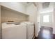 Laundry room with a modern washer and dryer set, shelving, and hardwood flooring at 5439 Bradford Pear Dr, Las Vegas, NV 89122