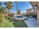 A serene backyard showcases a stone-accented pool with waterfall features and palm trees at 5442 Bristol Bend Ct, Las Vegas, NV 89135
