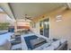 Covered patio featuring comfortable seating, ceiling fan, and access to outdoor entertainment area at 5442 Bristol Bend Ct, Las Vegas, NV 89135