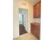 Hallway with tile floor and pantry with wooden cabinets and shelves at 5513 Silent Springs Dr, Las Vegas, NV 89122