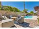 Outdoor living space featuring a refreshing pool, comfortable seating, and privacy wall at 5517 Bowerman Way, Las Vegas, NV 89130