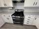 Modern kitchen features white cabinets, black hardware and stainless steel gas range with double oven at 5517 Bowerman Way, Las Vegas, NV 89130