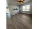 Bright living room with gray floors, large window, and view to kitchen and pool at 5517 Bowerman Way, Las Vegas, NV 89130