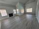 Open-concept living room with fireplace, large windows, and modern gray flooring at 5517 Bowerman Way, Las Vegas, NV 89130