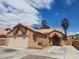 View of single-story house featuring stucco walls, tile roof, two-car garage, and an arched entryway at 5536 Cleary Ct, Las Vegas, NV 89108