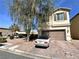 Two-story home with a two car garage and a brick driveway with a well manicured front yard at 5634 Bishop Flowers St, Las Vegas, NV 89130