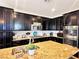 Kitchen with dark cabinets, granite countertops, stainless steel appliances and tile backsplash at 5634 Bishop Flowers St, Las Vegas, NV 89130