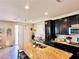 Kitchen island with granite countertop and seating, dark cabinets, stainless steel appliances and tile backsplash at 5634 Bishop Flowers St, Las Vegas, NV 89130