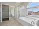 Bright bathroom featuring a soaking tub under an arch window, a shower, and a walk-in closet at 5655 Danforth Ave, Las Vegas, NV 89141