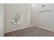 Bright living space featuring neutral carpet, high ceilings, and a large window with blinds at 5655 Danforth Ave, Las Vegas, NV 89141