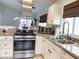 Kitchen with stainless steel appliances, granite counters, and white cabinets illuminated by natural light at 5929 Royal Castle Ln, Las Vegas, NV 89130