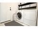 Laundry room with washer, dryer, storage shelves, and decorative flooring at 5929 Royal Castle Ln, Las Vegas, NV 89130