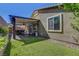 Backyard view featuring a covered patio, artificial grass, and well-maintained landscaping at 5957 Olivine Falls Ave, Las Vegas, NV 89130
