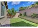 Landscaped backyard with artificial grass, flowering plants, and stone accents at 5957 Olivine Falls Ave, Las Vegas, NV 89130