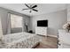 Bedroom features a ceiling fan, natural light, wood-look floors, and neutral paint at 5957 Olivine Falls Ave, Las Vegas, NV 89130