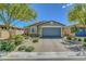 Charming single-story home featuring a two-car garage and a beautifully landscaped front yard at 5957 Olivine Falls Ave, Las Vegas, NV 89130