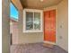 Welcoming front entry featuring a brick-paved porch and an orange front door at 5957 Olivine Falls Ave, Las Vegas, NV 89130
