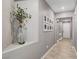 Hallway featuring tiled floors, neutral paint, decorative shelving and a collection of framed photographs at 5957 Olivine Falls Ave, Las Vegas, NV 89130