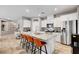 Bright kitchen features granite counters, stainless appliances, large island with seating, and access to pantry at 5957 Olivine Falls Ave, Las Vegas, NV 89130