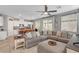 Spacious living room featuring a large sectional sofa and open layout with the kitchen and backyard access at 5957 Olivine Falls Ave, Las Vegas, NV 89130