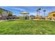Community playground with covered play area and picnic tables on lush green lawn at 5957 Olivine Falls Ave, Las Vegas, NV 89130