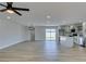 Open-concept living room with wood-look tile flooring and updated kitchen featuring stainless steel appliances at 6100 Fawn Cir, Las Vegas, NV 89107