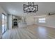 Bright, open living area with wood-look tile and modern lighting fixtures and a sliding door to the backyard at 6100 Fawn Cir, Las Vegas, NV 89107