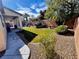 Green backyard space featuring manicured grass, easy-care landscaping and a covered porch area for outdoor living at 6134 Burleson Ranch Rd, Las Vegas, NV 89131