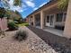 Lush backyard with a covered patio, rock landscape, and mature shrubs at 6134 Burleson Ranch Rd, Las Vegas, NV 89131