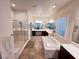 Bright bathroom featuring a soaking tub, glass shower and double sinks with modern fixtures at 6134 Burleson Ranch Rd, Las Vegas, NV 89131