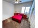Bedroom with neutral carpet, bright red comforter, and matching wood nightstands with lamps at 6134 Burleson Ranch Rd, Las Vegas, NV 89131