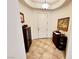 Inviting entryway boasts neutral tile floors, artful decor, and a tray ceiling with a classic light fixture at 6134 Burleson Ranch Rd, Las Vegas, NV 89131