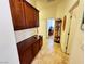 Hallway featuring tile flooring, dark wood cabinets for storage, and arched opening looking into room at 6134 Burleson Ranch Rd, Las Vegas, NV 89131