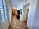 Well-lit hallway with tile flooring and white walls leading to various rooms of the house at 6134 Burleson Ranch Rd, Las Vegas, NV 89131