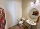 Powder room with tiled floors, pedestal sink, and decorative mirror at 6134 Burleson Ranch Rd, Las Vegas, NV 89131