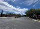 Street view in a neighborhood with mature trees under a blue sky with scattered clouds at 6134 Burleson Ranch Rd, Las Vegas, NV 89131