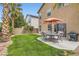 Lush backyard with patio seating, lawn, grill and privacy fence at 6390 Whispering Clouds Ct, Las Vegas, NV 89141